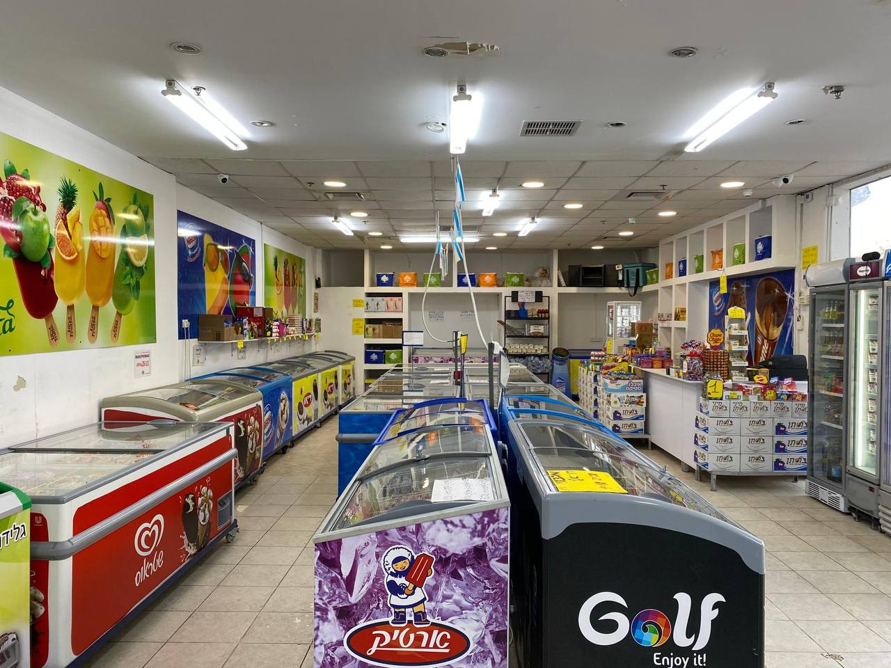 החנות של ריאו בעיר, מקפיאי תצוגה מלאים בגלידות, ארטיקים וקינוחים קפואים מכל המותגים